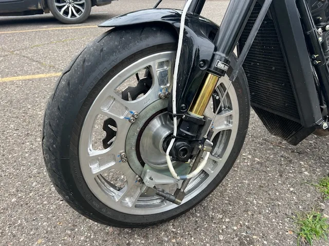 Vorderrad eines Motorrads mit einem Messrad in der Felge und seiner Telemetrie-Statorhalterung an der Gabel