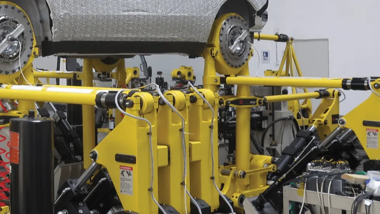 Car on a hub-coupled road simulator, its wheel positions fitted with wheel force transducers and connected to the yellow actuators