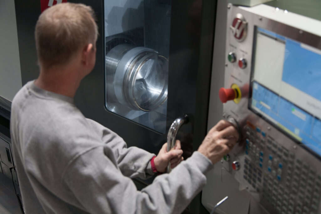 Machinist at the control panel of a CNC machining center