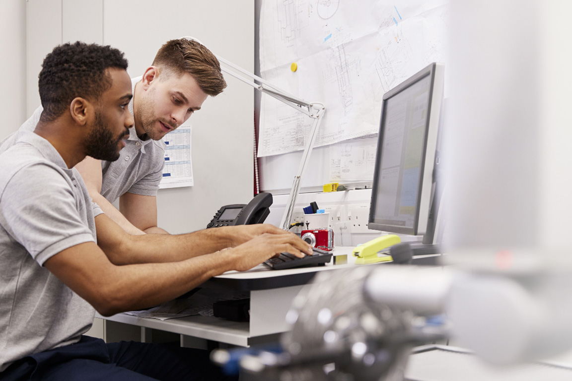 Two engineers looking at measurement data on a screen