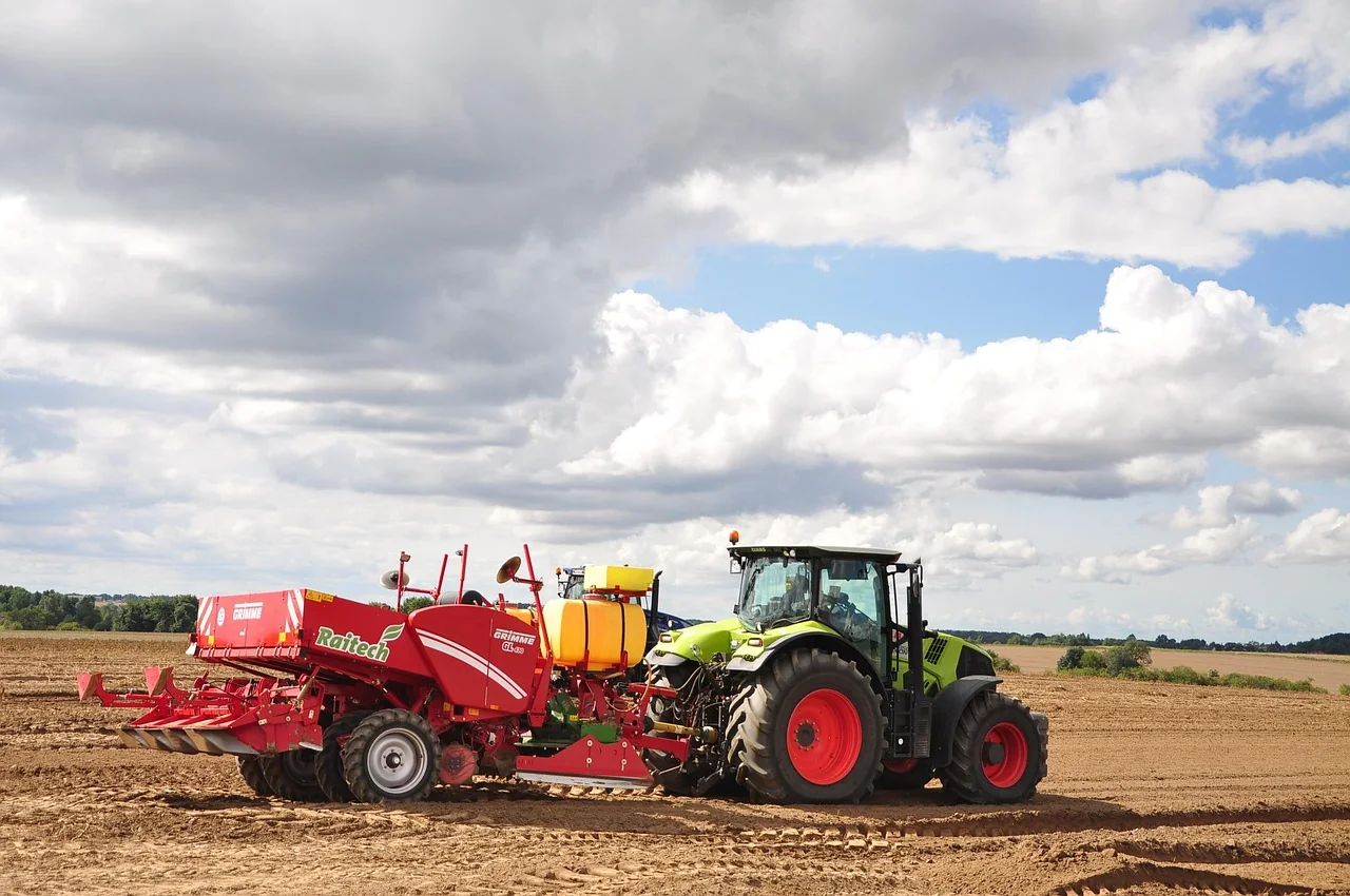 Tractor plowing a field, with a wheel torque transducer on its rear wheel