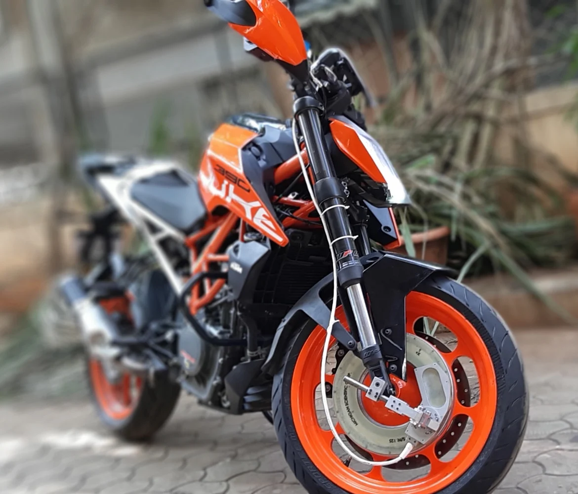 Motorcycle with a wheel force transducer on its front wheel and a cable running up the fork