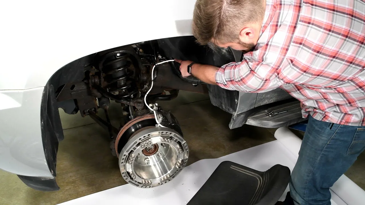 Tecnico che installa una ruota dinamometrica a telemetria LW65 sul mozzo anteriore di un’automobile