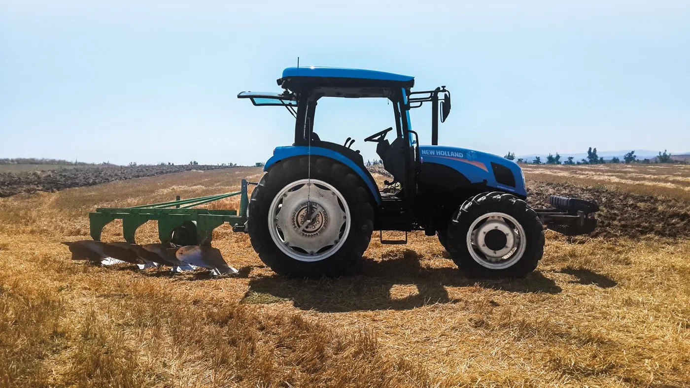 Trattore che ara un campo con ruote dinamometriche sui due assi