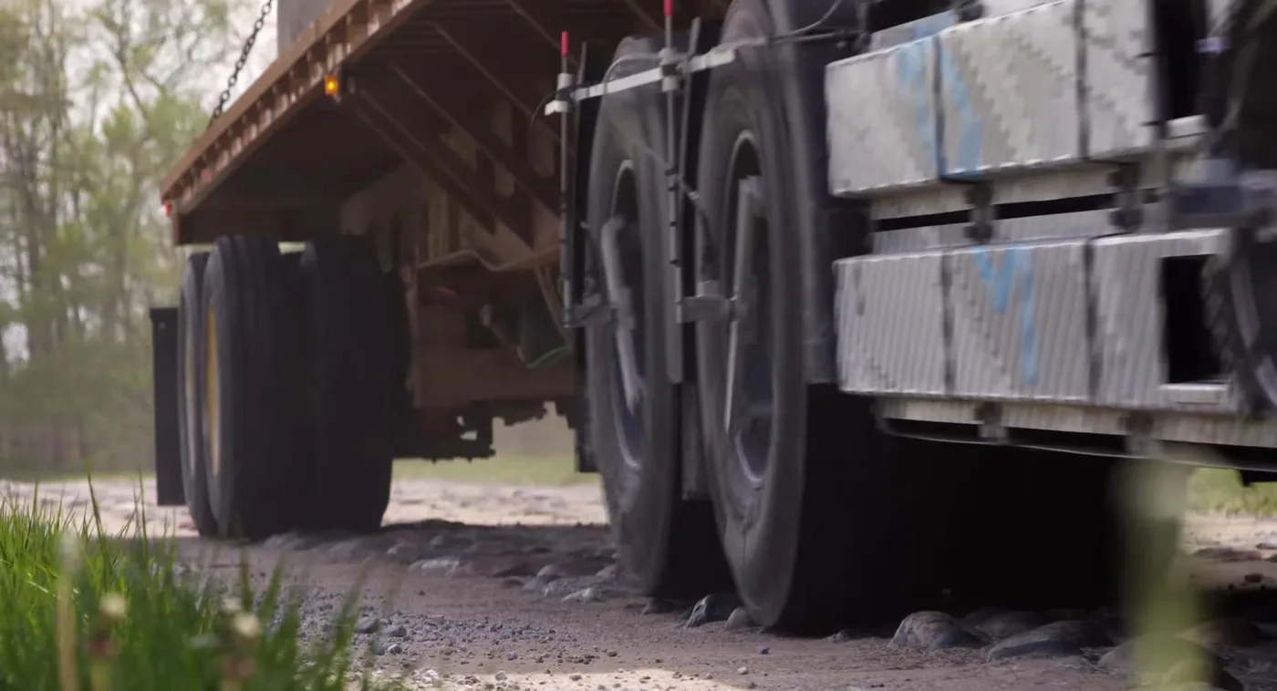 Heavy truck with wheel force transducers on a gravel road